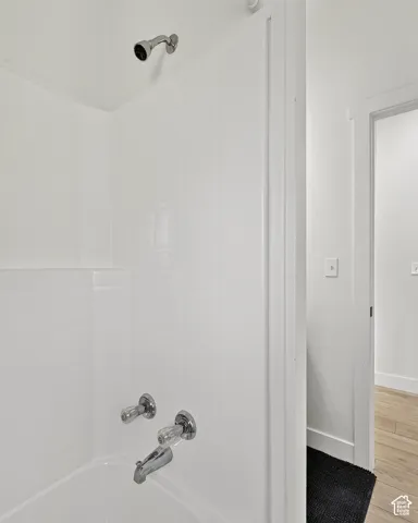 Bathtub and shower combination with a white subway tile surround and chrome fixtures