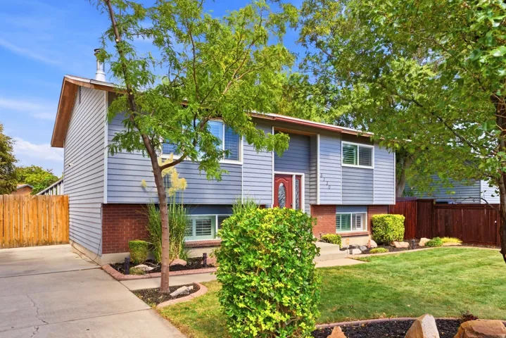 Light blue horizontal siding with red brick base