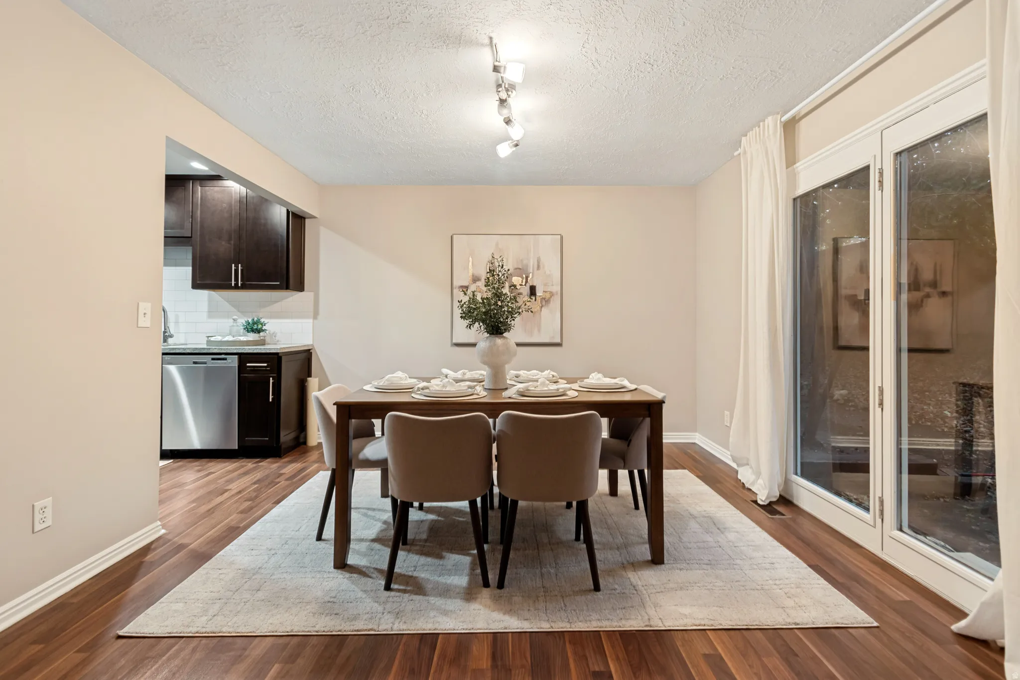 Wood-finish flooring throughout, track lighting fixture, and white trim