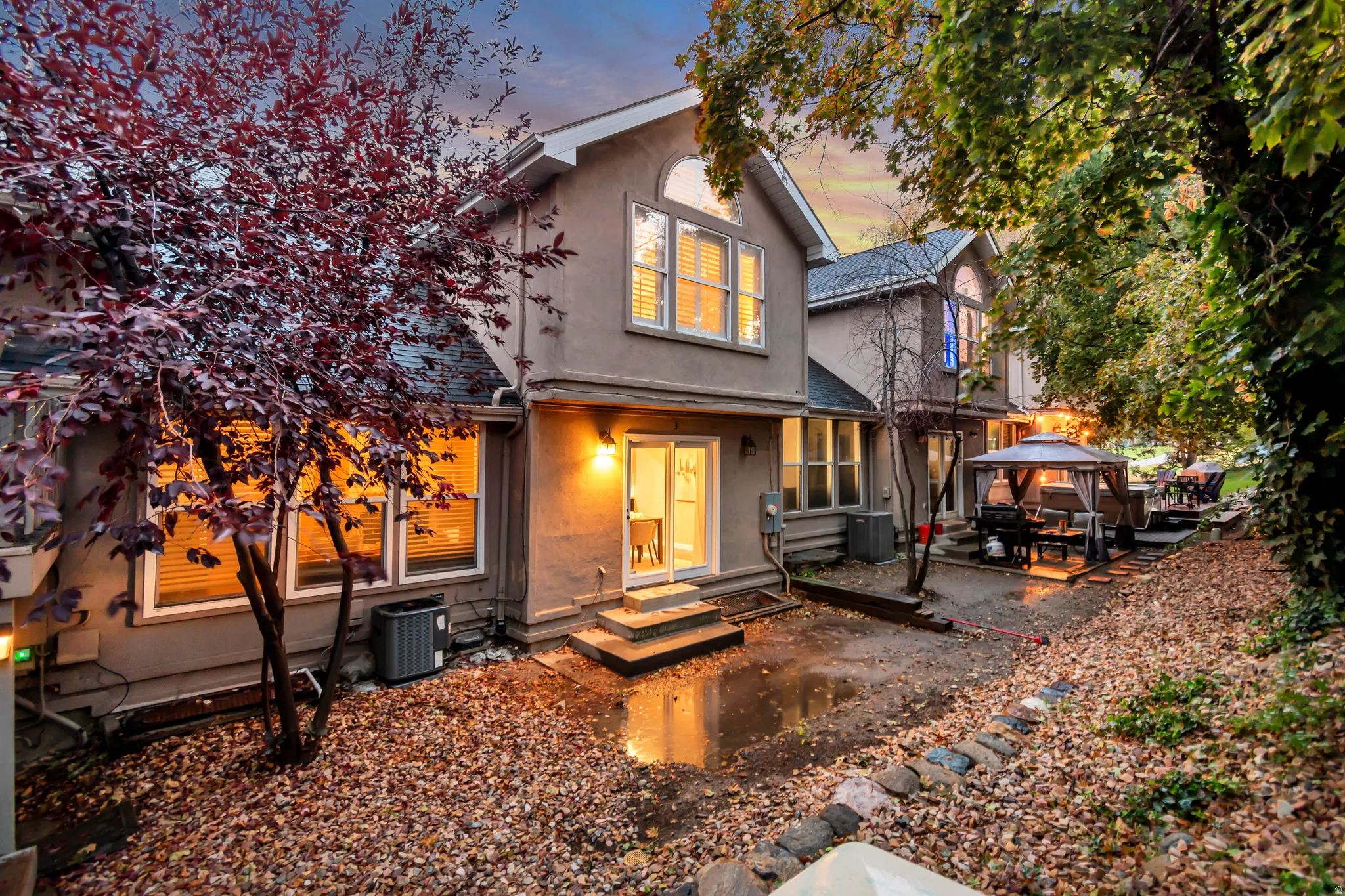 Rear exterior with stucco finish, multiple windows, and a multi-level outdoor area