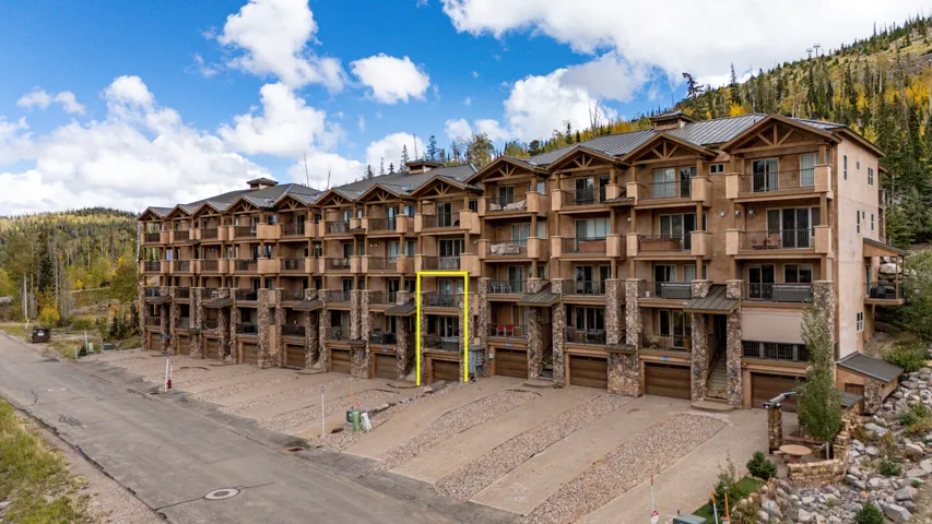 Multi-level residence featuring stone and stucco exterior, multiple private balconies, and an integrated garage
