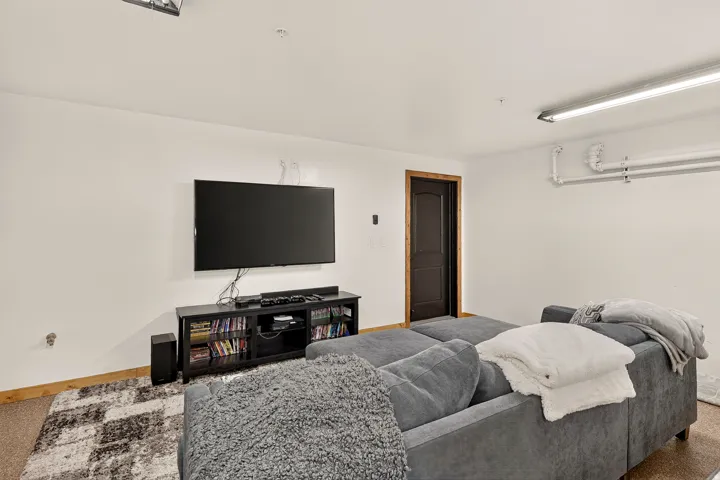 Recessed lighting, wood-trim doorway, wall-mounted television, and carpet flooring
