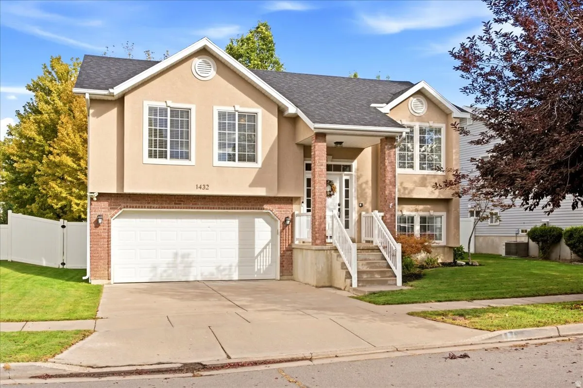 Two-story residence featuring a stucco and brick exterior, an attached two-car garage, and a concrete driveway