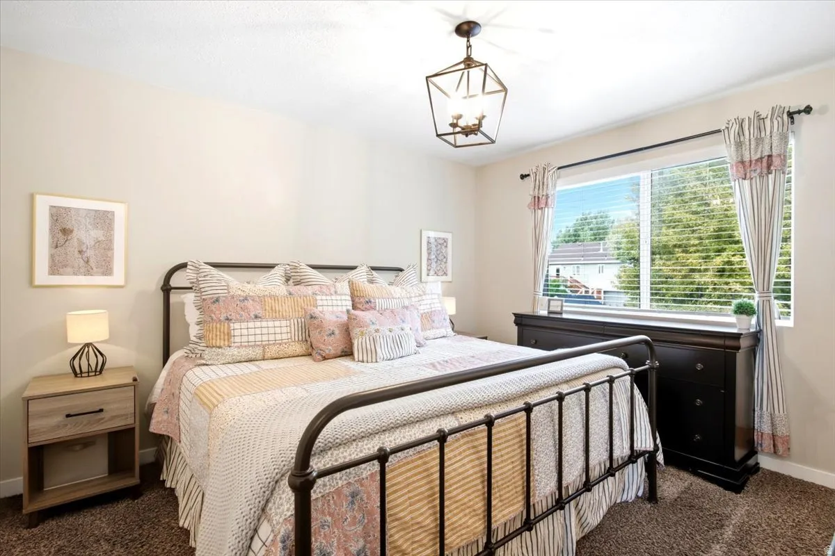 Recessed lighting, large window with blinds, dark wood-finish dresser, and light wood-finish nightstand