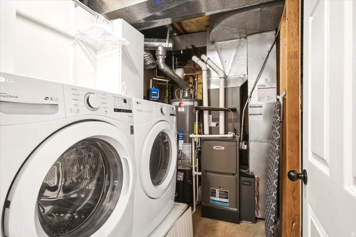 Laundry area with a front-loading washer and dryer, gas furnace, and water heater