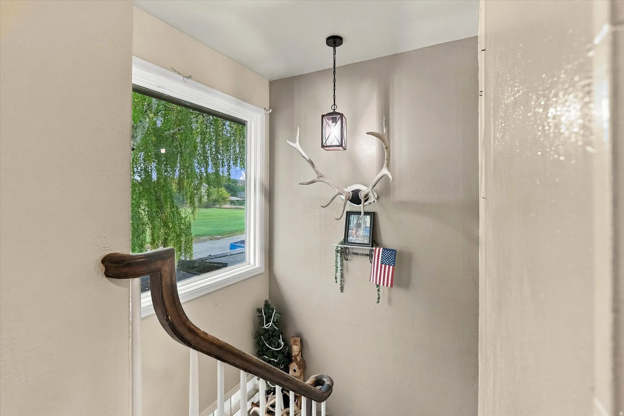 Staircase featuring a wood handrail, white balusters, and a window with white trim