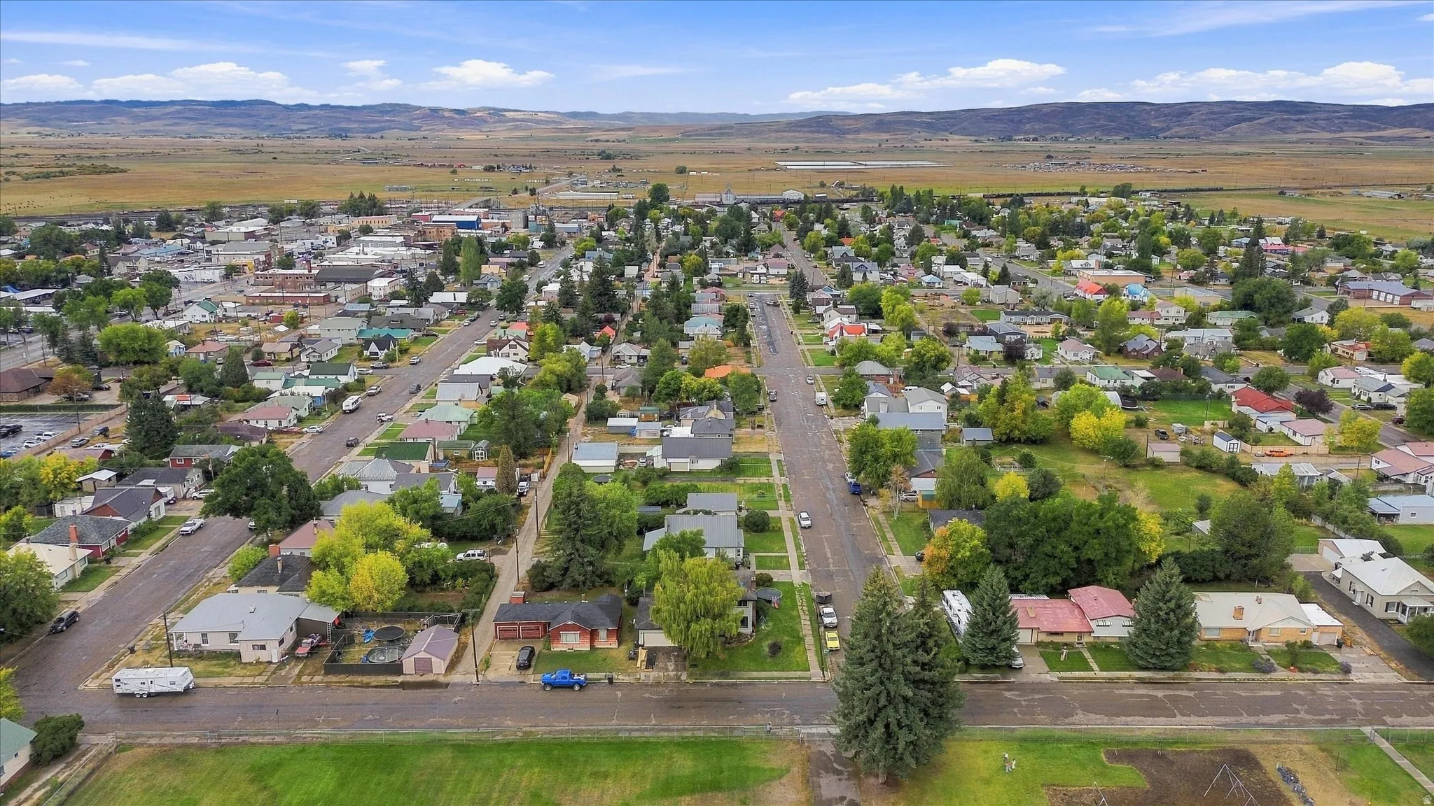 Aerial perspective of a developed community featuring established homes, paved streets, and mature landscaping