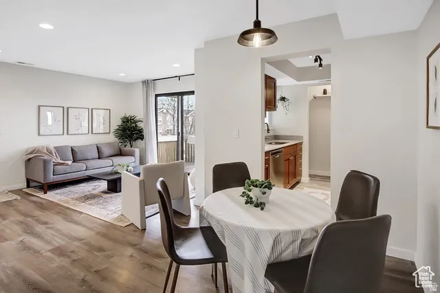 Recessed lighting, wood-finish flooring, sliding glass door, recessed kitchen area, and a semi-flush mount light fixture