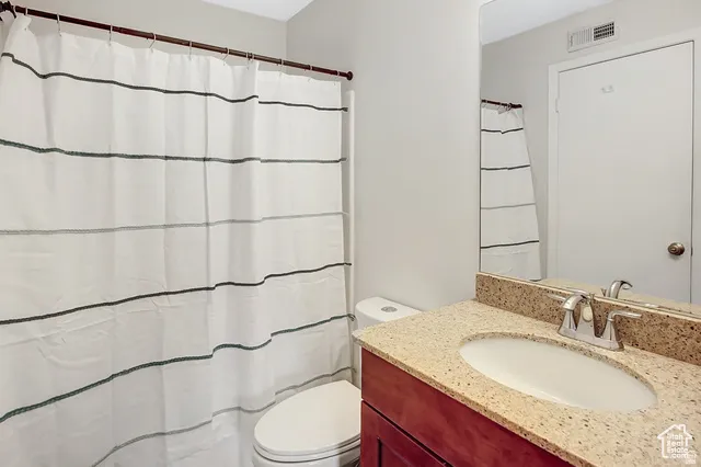 Bathroom featuring a vanity with an integrated sink, a speckled countertop, and a chrome faucet