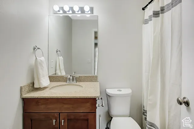 Wood-finish vanity with an integrated sink, polished chrome faucet, and a wall-mounted vanity mirror