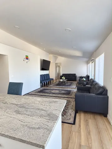 Recessed lighting, wood-finish flooring, white walls, and a light-toned countertop
