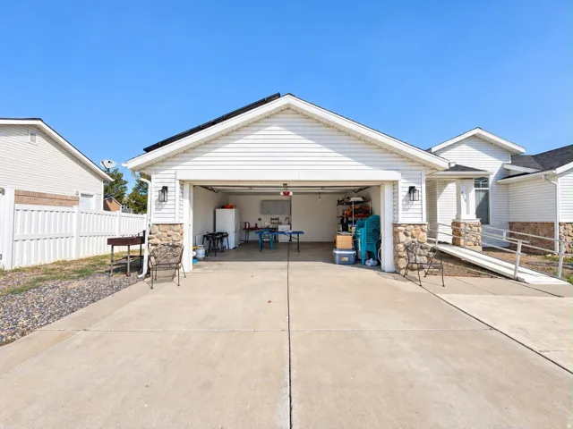 Attached two-car garage with stone accents and two exterior wall-mounted lights