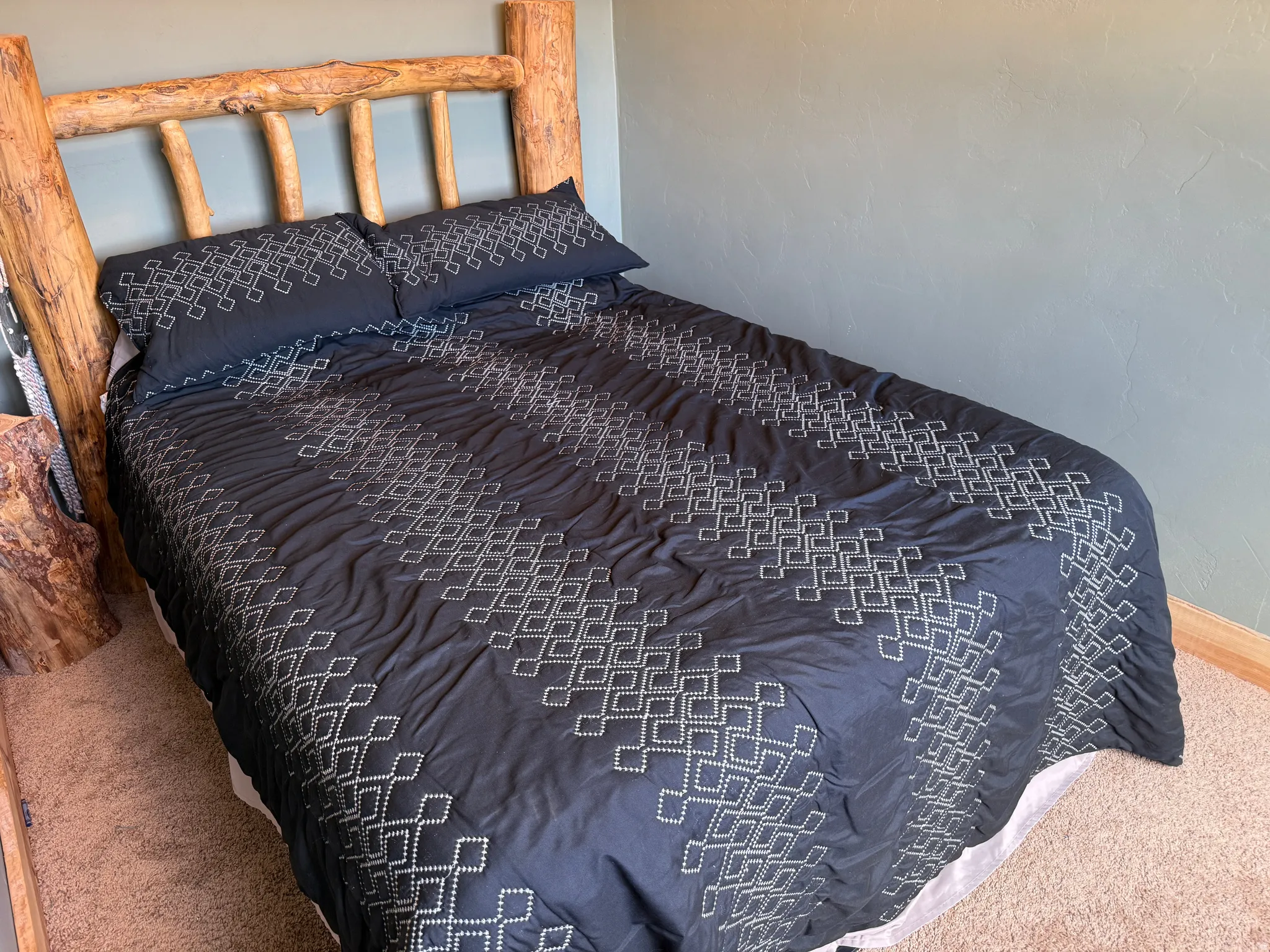 Carpeted flooring, textured wall finish, and wood baseboard trim
