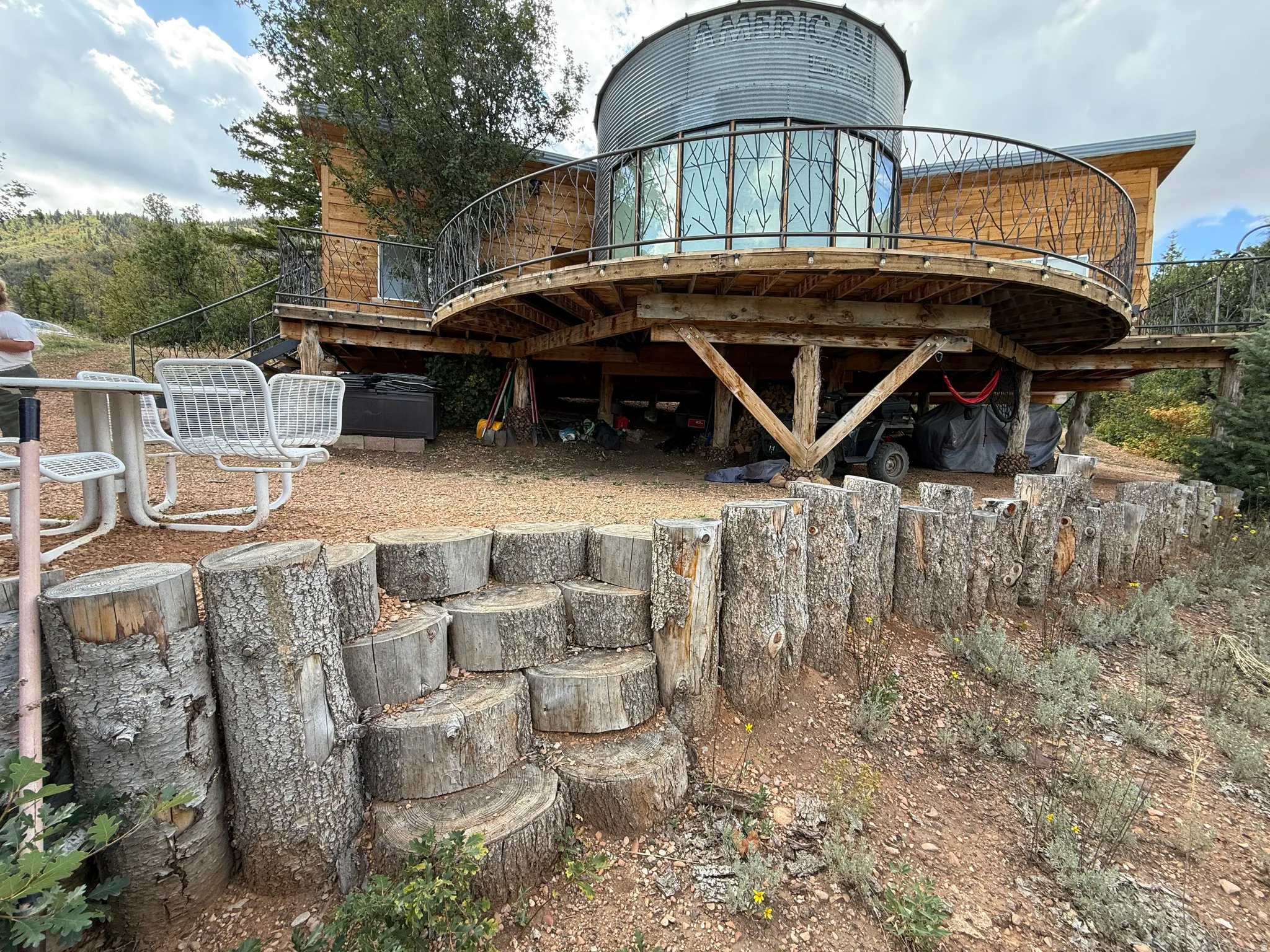 Unique architectural design with a circular deck featuring decorative metal railing