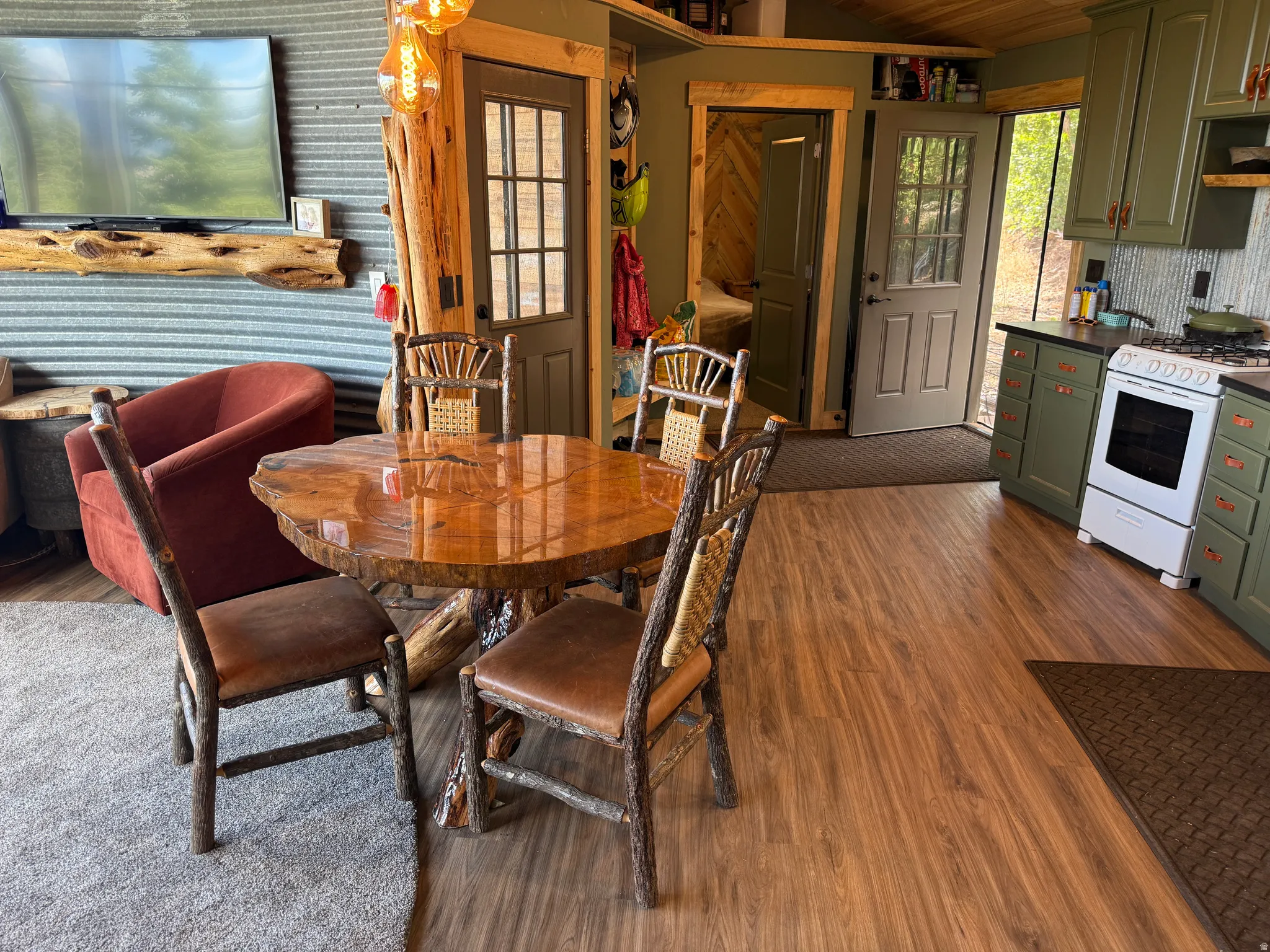 Wood-finish flooring throughout, featuring a kitchen with shaker-style cabinetry and a range
