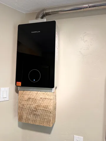 Wall-mounted tankless water heater with metal venting