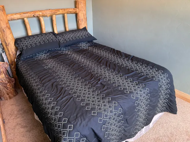 Carpeted flooring, textured wall finish, and wood baseboard trim