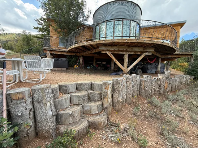 Unique architectural design with a circular deck featuring decorative metal railing