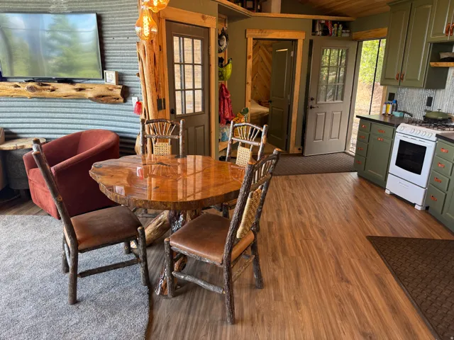 Wood-finish flooring throughout, featuring a kitchen with shaker-style cabinetry and a range