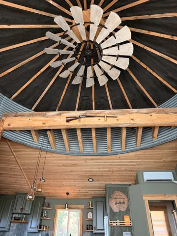 Vaulted ceiling with an industrial-style ceiling fan and wood beams