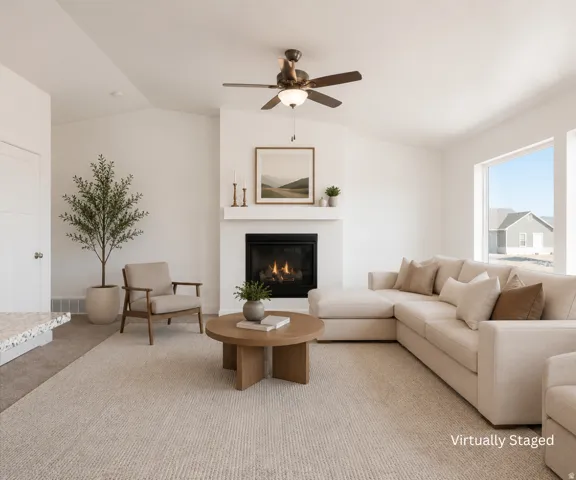 Vaulted ceiling with a ceiling fan, gas fireplace with a white mantel, large windows, and neutral carpet flooring