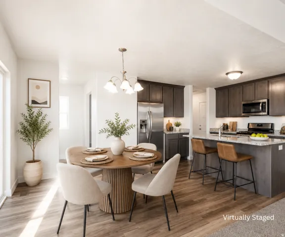 Open-concept living space with wood-finish flooring, a kitchen island with seating, stainless steel appliances, dark wood cabinetry, and recessed lighting