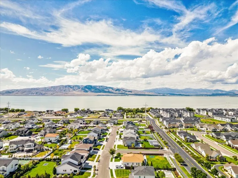Expansive residential area with a prominent lake and mountain range backdrop