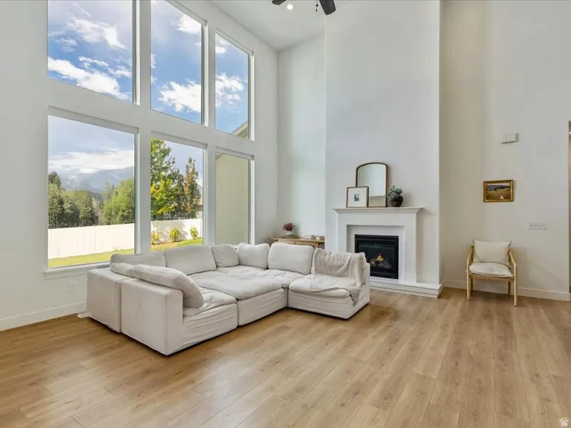 Two-story windows, vaulted ceiling, wood-finish flooring, fireplace, and a white picket fence