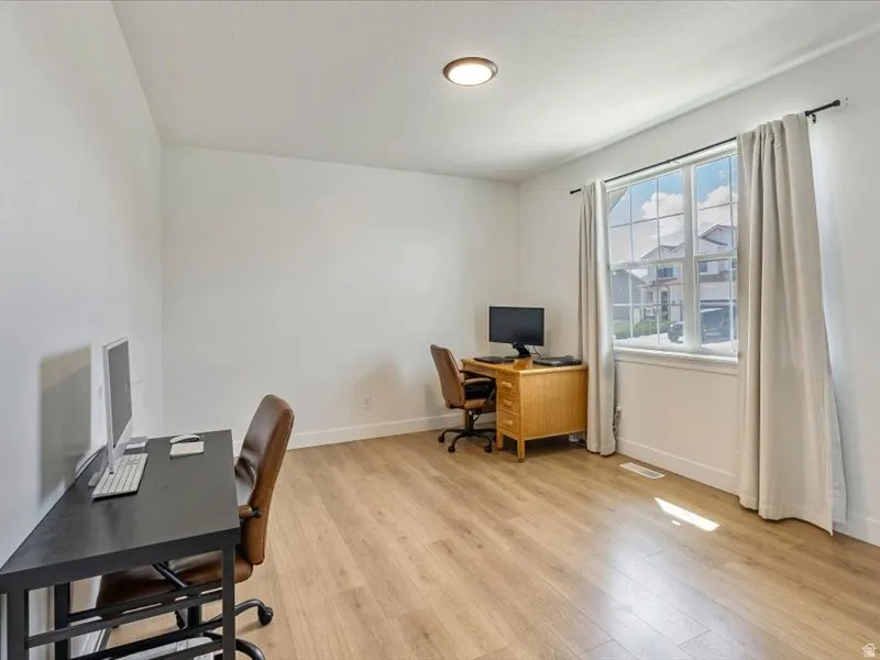 Recessed ceiling light, wood-finish flooring, white walls, and a large multi-pane window