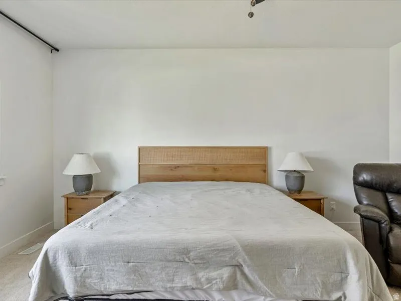 Carpeted flooring, white painted walls, and a ceiling fan
