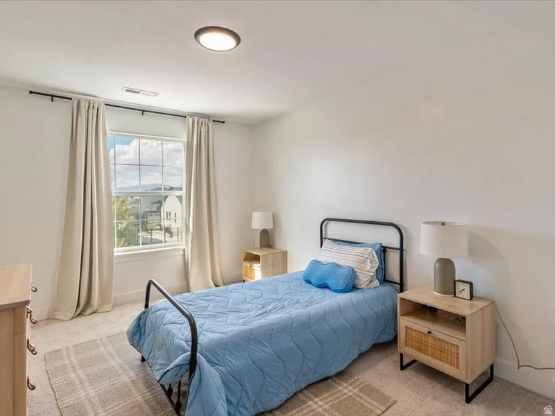 Recessed ceiling light, carpeted flooring, large window with multi-pane design, neutral wall color, and white trim