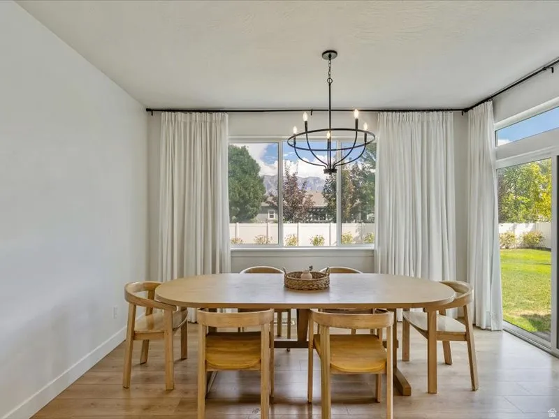 Expansive windows, wood-finish flooring, and a contemporary chandelier