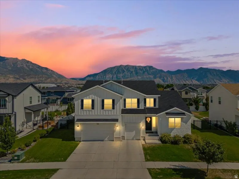 Two-story residence with a two-car garage, partial brick veneer facade, and mature landscaping