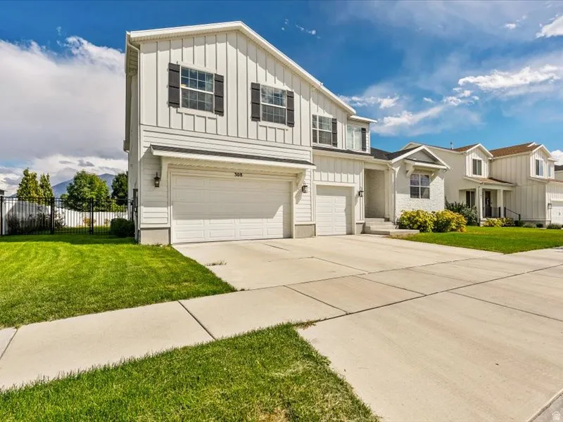 Two-story residence featuring white board and batten siding and a two-car garage