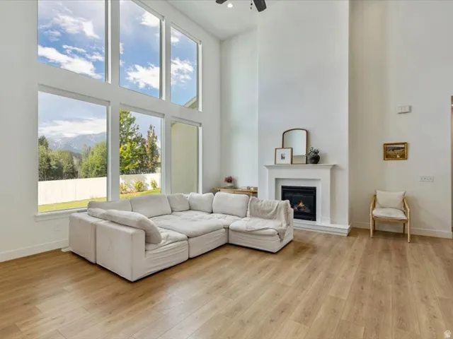 Two-story windows, vaulted ceiling, wood-finish flooring, fireplace, and a white picket fence