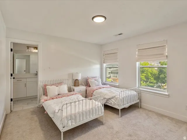 Carpeted room with two windows featuring Roman shades and a recessed ceiling light