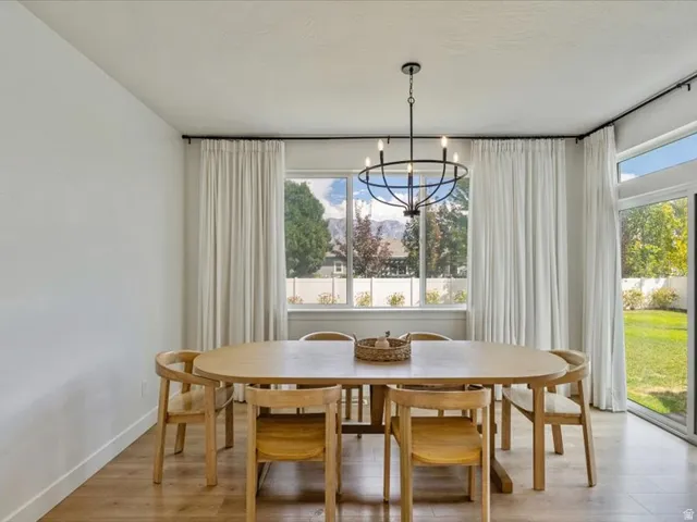 Expansive windows, wood-finish flooring, and a contemporary chandelier