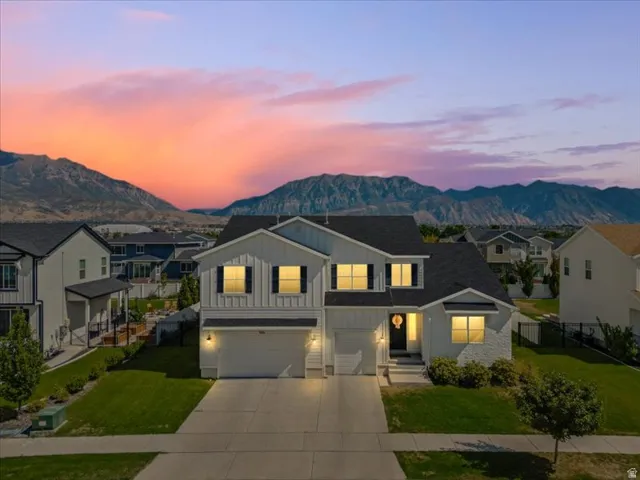 Two-story residence with a two-car garage, partial brick veneer facade, and mature landscaping