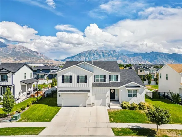 Two-story residence with a white exterior, black shutters, and an attached two-car garage