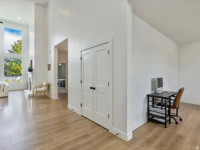 Wood-finish flooring throughout, bright white walls, and a recessed fireplace with a white mantel