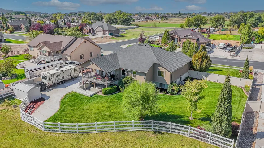 Spacious residential property with a multi-level deck, expansive grassy areas, and a concrete driveway