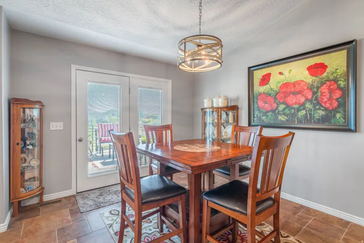 Tile flooring, double patio doors, neutral wall color, and a modern drum pendant light fixture