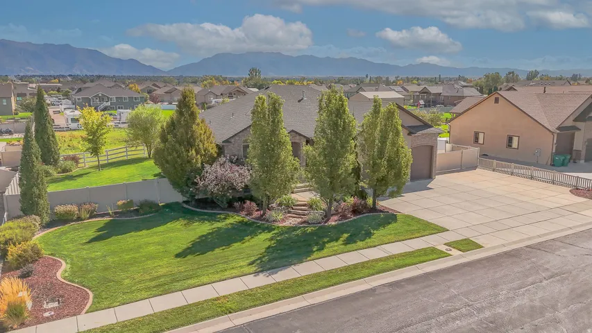 Expansive front lawn with mature trees and landscaped planting beds