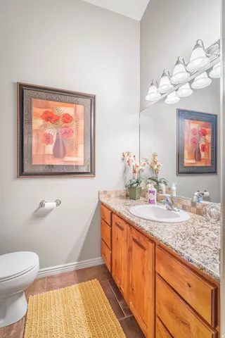 Wood-finish vanity with a granite-style countertop and integrated sink