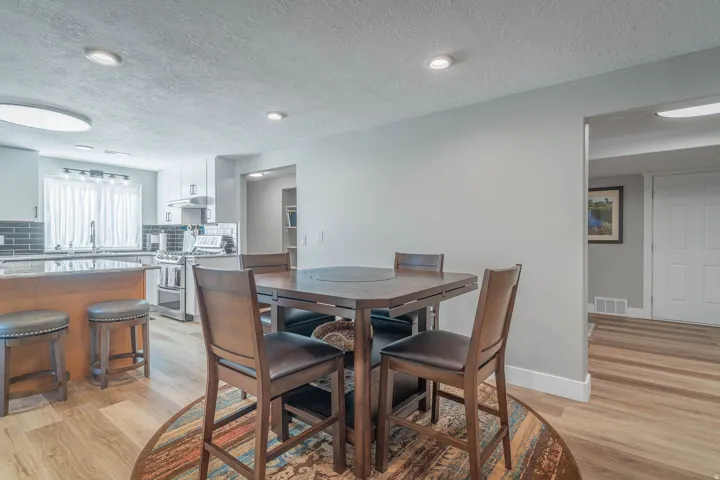 Kitchen featuring wood-finish flooring, recessed lighting, and a backsplash with dark subway tiles