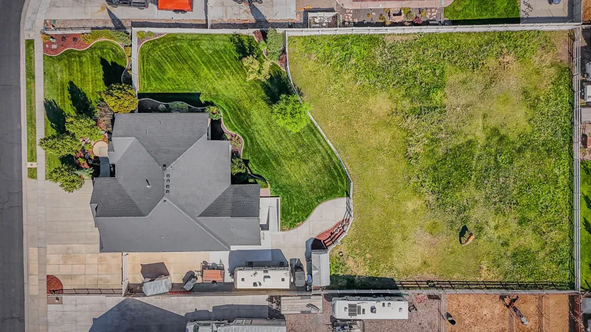 Expansive lot featuring a large residential structure with a shingle roof, paved driveway, and mature landscaping