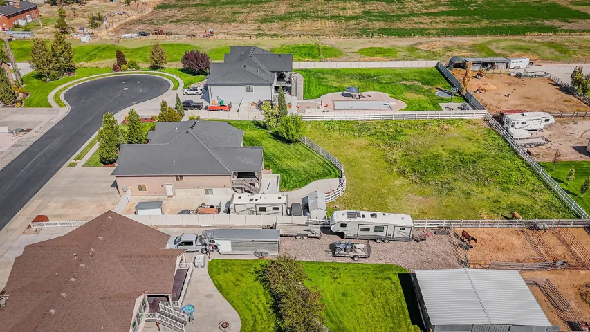 Expansive property featuring a paved cul-de-sac, green lawns, and perimeter fencing