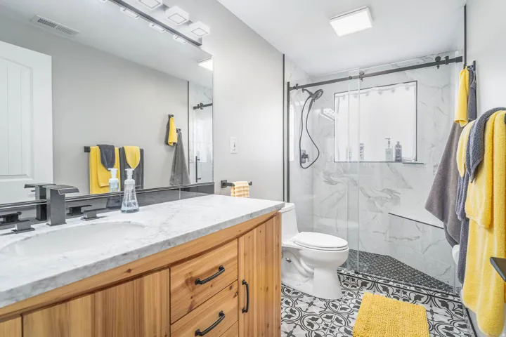 Wood-finish vanity with a white countertop and rectangular undermount sink
