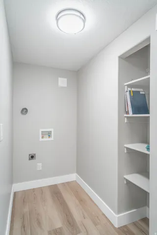 Wood-finish flooring, recessed shelving, modern flush-mount lighting, and light-toned wall paint
