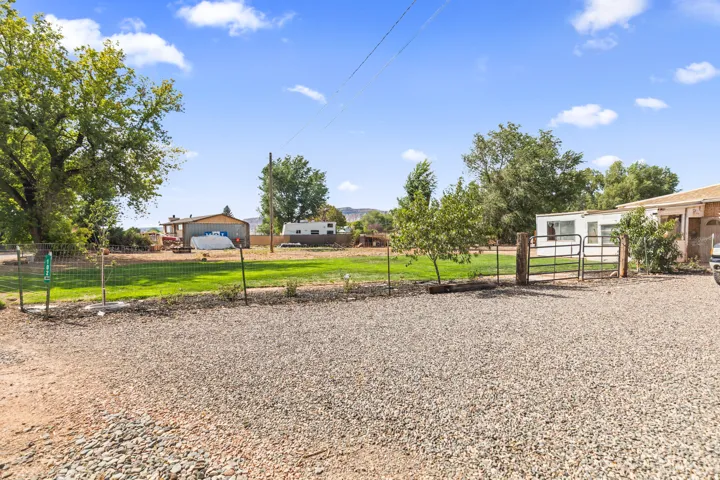 Gravel driveway with a metal gate and fencing